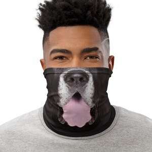 May include: A black and white dog face printed on a black neck gaiter. The dog's tongue is sticking out.