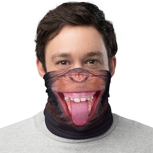 Pode incluir: Uma máscara facial preta com uma imagem impressa de um rosto de macaco com a língua de fora.