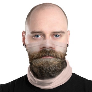 May include: A person wearing a beige face mask with a printed image of a man's face with a beard and mustache.