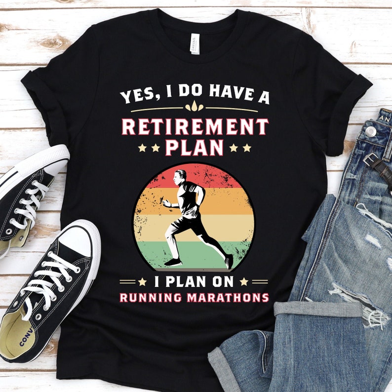 May include: Black t-shirt with a retro-style graphic of a runner. The text reads "YES, I DO HAVE A RETIREMENT PLAN I PLAN ON RUNNING MARATHONS".