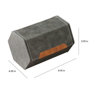 Op de afbeelding: Een grijze zeshoekige opbergdoos met een bruine leren klep en een gestikt ontwerp. De doos is 14,6 cm lang, 10,8 cm breed en 9,5 cm hoog.