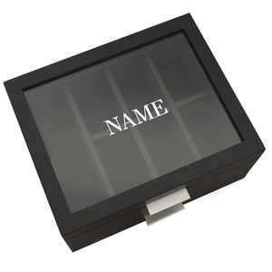 May include: Black wooden box with a clear lid and a drawer. The lid has compartments and the word "NAME" is printed on the front.