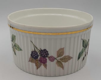 Op de afbeelding: Witte keramische ramekin met een gouden rand en een bramenontwerp. De ramekin heeft een geribbelde buitenkant.