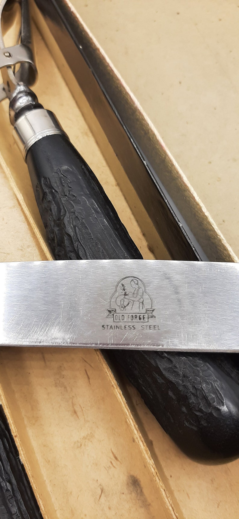 Puede incluir: Primer plano de un juego de cuchara y servidor de helado de acero inoxidable. Los mangos son negros con un dise&ntilde;o texturizado. El servidor tiene el texto "OLD FORGE STAINLESS STEEL".