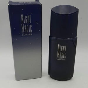 May include: A dark blue perfume bottle and box. The bottle has a cylindrical shape with a black cap. Both the box and bottle display the text "NIGHT MAGIC EVENING MUSK" in white. The box features a gradient design.