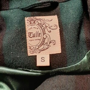 May include: A close-up of a green and black plaid jacket collar. The jacket has a satin lining and a label that reads "Tulle original clothing" with a size "S" label.