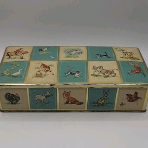 May include: Rectangular metal box with a hinged lid. The lid features a grid of squares with illustrations of farm animals, including a horse and rider, a duck, and a fox. The box has a gold-coloured trim.