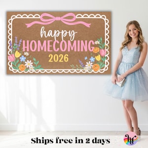 May include: A rectangular brown sign with a white scalloped border and a pink bow at the top. The text reads happy HOMECOMING 2026 in white and pink. The design features colorful illustrations of lavender, tulips, and daisies on both sides.