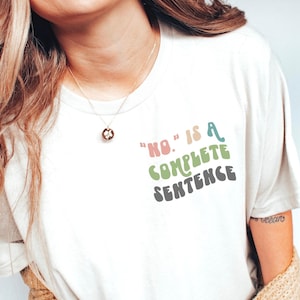 May include: White t-shirt with the text "NO." is a complete sentence" in colorful, retro-style lettering.