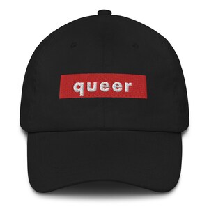 May include: A black baseball cap with a red box and the word "queer" in white lettering.