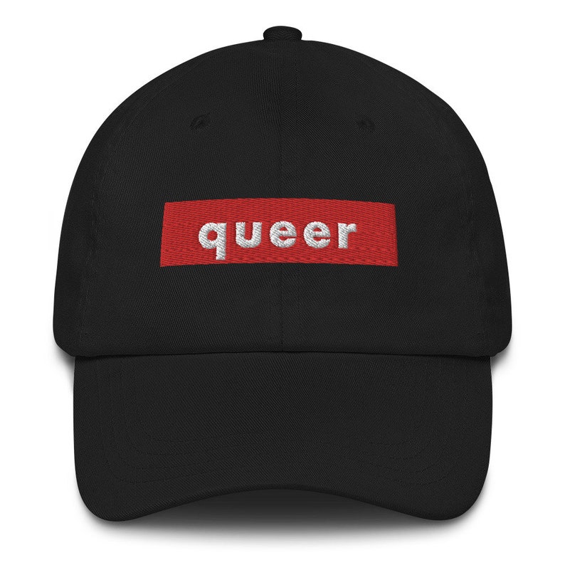 May include: A black baseball cap with a red box and the word "queer" in white lettering.