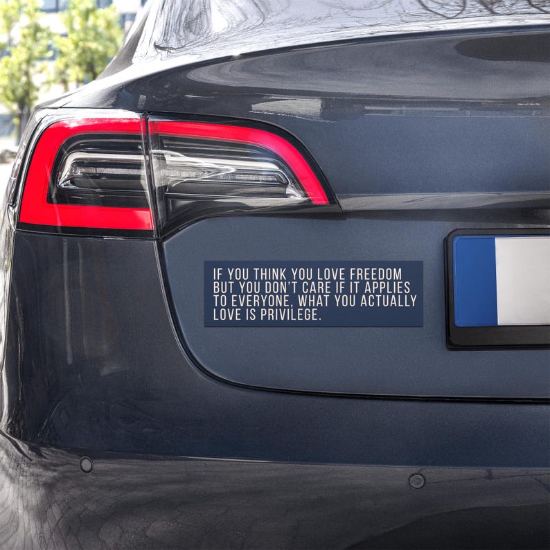 May include: A navy blue car bumper sticker with white text. The text reads: "IF YOU THINK YOU LOVE FREEDOM BUT YOU DON'T CARE IF IT APPLIES TO EVERYONE, WHAT YOU ACTUALLY LOVE IS PRIVILEGE."