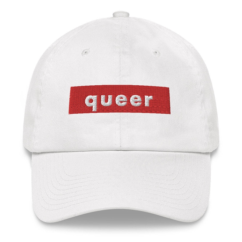 May include: White baseball cap with a red box that says "queer" in white letters.