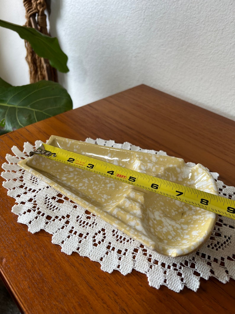 May include: A yellow ceramic dish with white speckles. The dish has three sections and is 8 inches long.