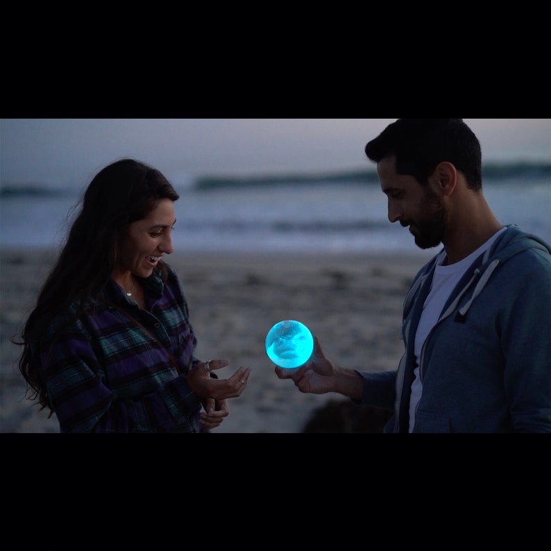 glowing bio-orb handed from one person to the next