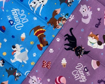 Può includere: Due tessuti fantasia con personaggi Disney. Uno è blu con personaggi di cani e la scritta "I love my Disney Dog". L'altro è viola con personaggi di gatti e la scritta "I love my Disney Cat".