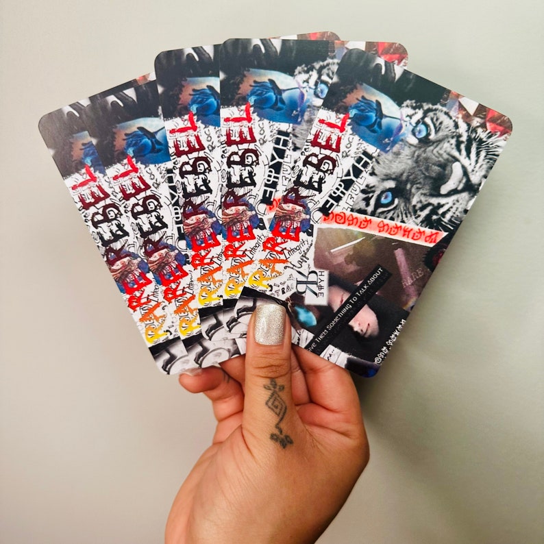 Puede incluir: Una pila de tarjetas coloridas con la palabra "REBEL" impresa en ellas. Las tarjetas tienen un collage de im&aacute;genes, incluyendo un tigre, la cara de una persona y el texto "Have something to talk about".