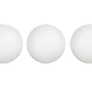 May include: Three white foam spheres are arranged horizontally against a white background. The spheres are evenly spaced and have a slightly textured surface. They are likely used for crafts or decorative purposes.