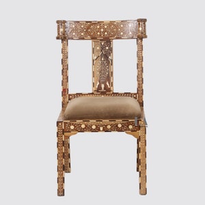 May include: A wooden chair with intricate floral inlay work in a light brown and dark brown wood. The chair has a brown fabric seat.