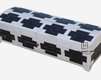 May include: A white and black bone inlay box with a geometric pattern. The box has a hinged lid and a small metal latch. The box is made by Leelawati Art.