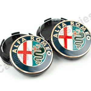 Pode incluir: Duas calotas de roda Alfa Romeo pretas e douradas com um logotipo branco, vermelho e verde. O logotipo apresenta uma cruz e uma cobra.