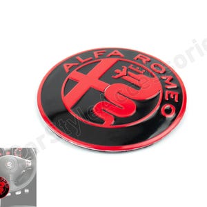 May include: A black and red Alfa Romeo emblem with a snake design. The emblem is a 3D sticker with a glossy finish.