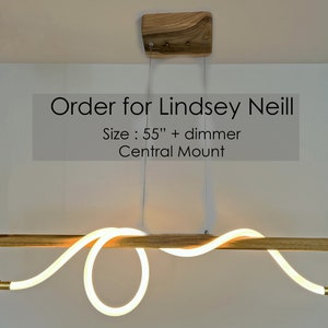 May include: A modern, wooden light fixture with a white, curved LED light. The fixture is 55 inches long and has a central mount. The text "Order for Lindsey Neill" and "Size: 55" + dimmer Central Mount" is visible in the image.