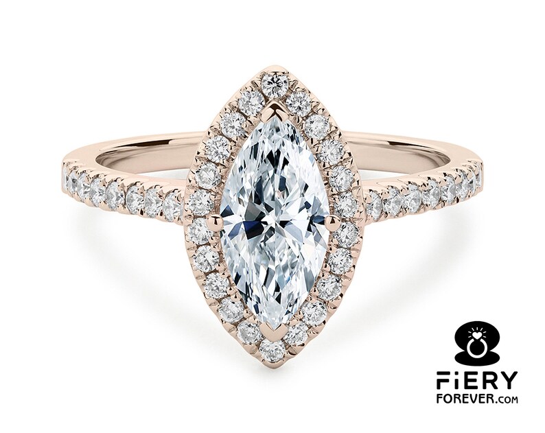 May include: A rose gold engagement ring with a marquise-shaped diamond center stone surrounded by a halo of smaller diamonds. The band is also set with smaller diamonds.