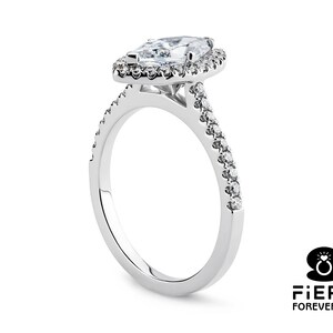 May include: A silver engagement ring with a marquise-shaped diamond center stone surrounded by a halo of smaller diamonds. The band is also set with smaller diamonds.