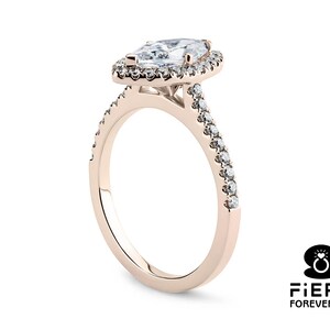 May include: A rose gold engagement ring with a pear-shaped diamond center stone and a halo of smaller diamonds. The band is also set with smaller diamonds.