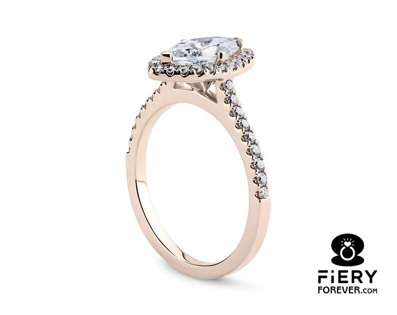May include: A rose gold engagement ring with a pear-shaped diamond center stone and a halo of smaller diamonds. The band is also set with smaller diamonds.