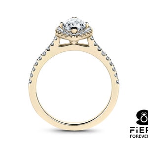 May include: A gold engagement ring with a pear-shaped diamond center stone and a halo of smaller diamonds. The band is also set with smaller diamonds.