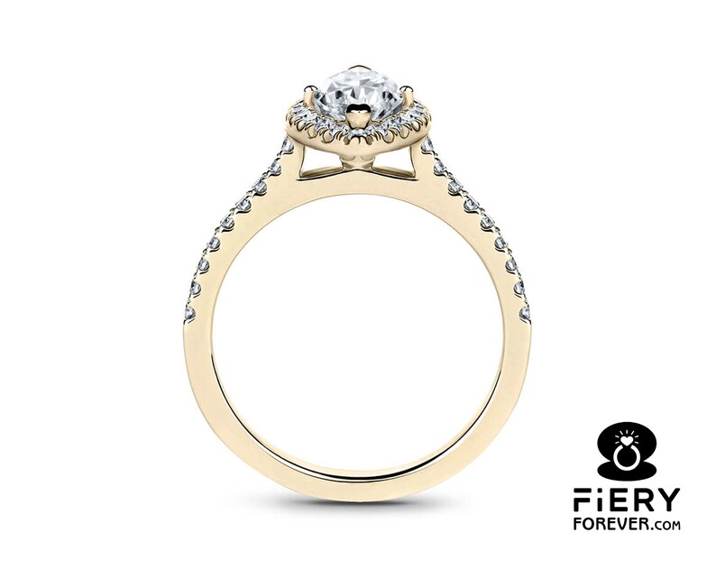 May include: A gold engagement ring with a pear-shaped diamond center stone and a halo of smaller diamonds. The band is also set with smaller diamonds.