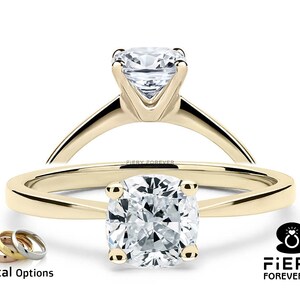 May include: A gold engagement ring with a cushion-cut diamond. The ring is shown in a close-up view with the diamond facing the camera. The ring is also shown from the side, with the band visible. The image includes the text "Fiery Forever.com".