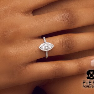 May include: A silver ring with a marquise-shaped diamond center stone and a halo of smaller diamonds.