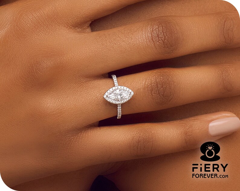 May include: A silver ring with a marquise-shaped diamond center stone and a halo of smaller diamonds.