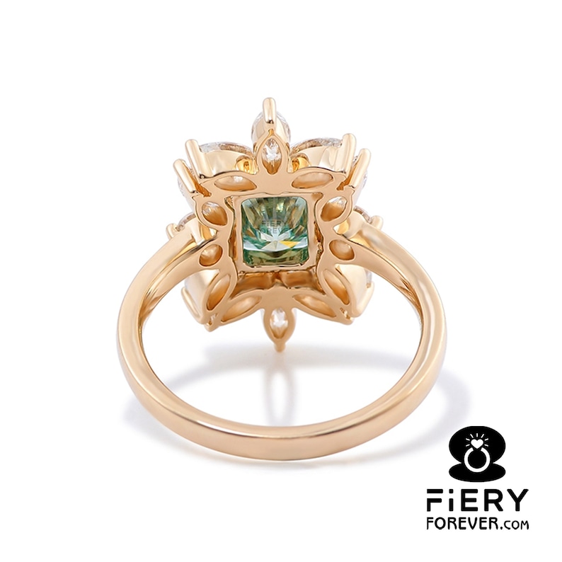 May include: A gold ring with a green gemstone surrounded by smaller clear gemstones in a floral design.