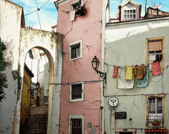 May include: A narrow, cobbled street in a European city with a pink building on the left and a green building on the right. Clothes are hanging on a washing line between the buildings. The street leads up a set of steps to an archway.