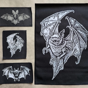 Könnte beinhalten: Schwarze Stoffaufnäher mit weißen Fledermaus-Illustrationen. Die Aufnäher sind unterschiedlich groß und zeigen detaillierte Zeichnungen von Fledermäusen mit ausgebreiteten Flügeln. Die Fledermäuse haben ein gotisches oder Halloween-Thema.