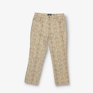 May include: Beige trousers with a brown and white animal print pattern.