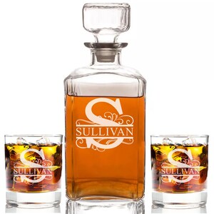 May include: A personalized decanter set with two glasses. The decanter and glasses are etched with a decorative initial "S" and the name "Sullivan".
