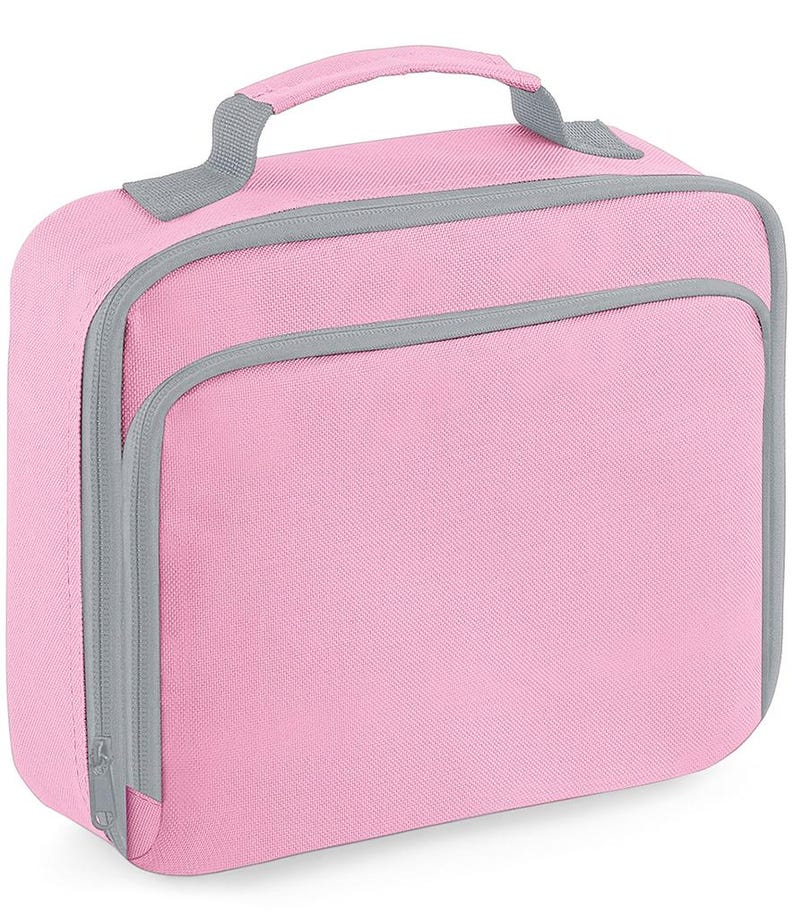 Puede incluir: Una bolsa de almuerzo rectangular de color rosa claro s&oacute;lido con ribetes grises y cierre de cremallera gris. La bolsa cuenta con un asa superior para llevarla y un bolsillo frontal con cremallera. El exterior es de tela texturizada.