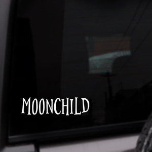 May include: A black car window with a white vinyl decal that reads "MOONCHILD".