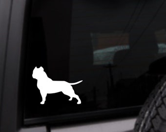 May include: White silhouette of a pit bull dog on a black background. The dog is standing on all four legs with its head turned to the side.