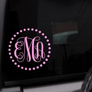 May include: Pink monogram decal with the letters "EMA" in a script font, surrounded by a circle of small pink dots.