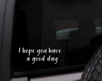 May include: A black car window with a white vinyl decal that reads "I hope you have a good day".