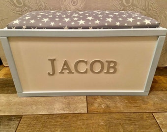 Personalised toy box with safety gas strut.