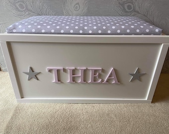 Personalised toy box with safety gas strut.