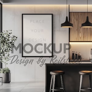 Puede incluir: Una maqueta de póster enmarcada en negro con el texto "PLACE YOUR DESIGN HERE" colgada en una pared de hormigón blanco en una cocina moderna. La cocina cuenta con una encimera negra con dos taburetes de bar negros, un armario de madera y luces colgantes negras.