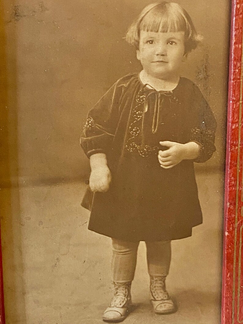 1800s Sepia photograph of an adorable child with precious innocent face Comes in red and gold frame.
